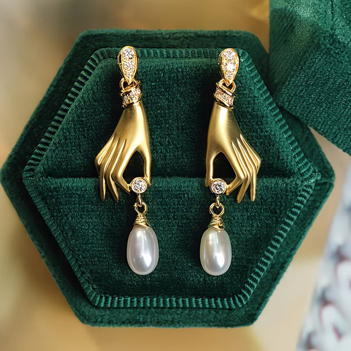 Boucles d'oreilles en perles avec main élégante